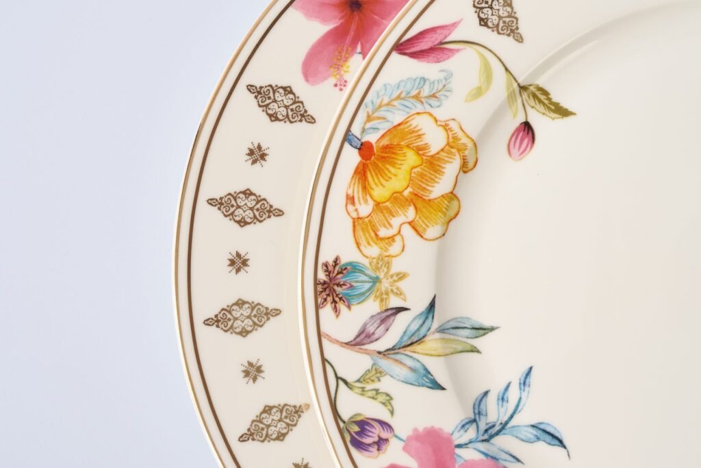 Close-up of two Casa Aseana dessert plates, a gold songket rim beside a floral rim